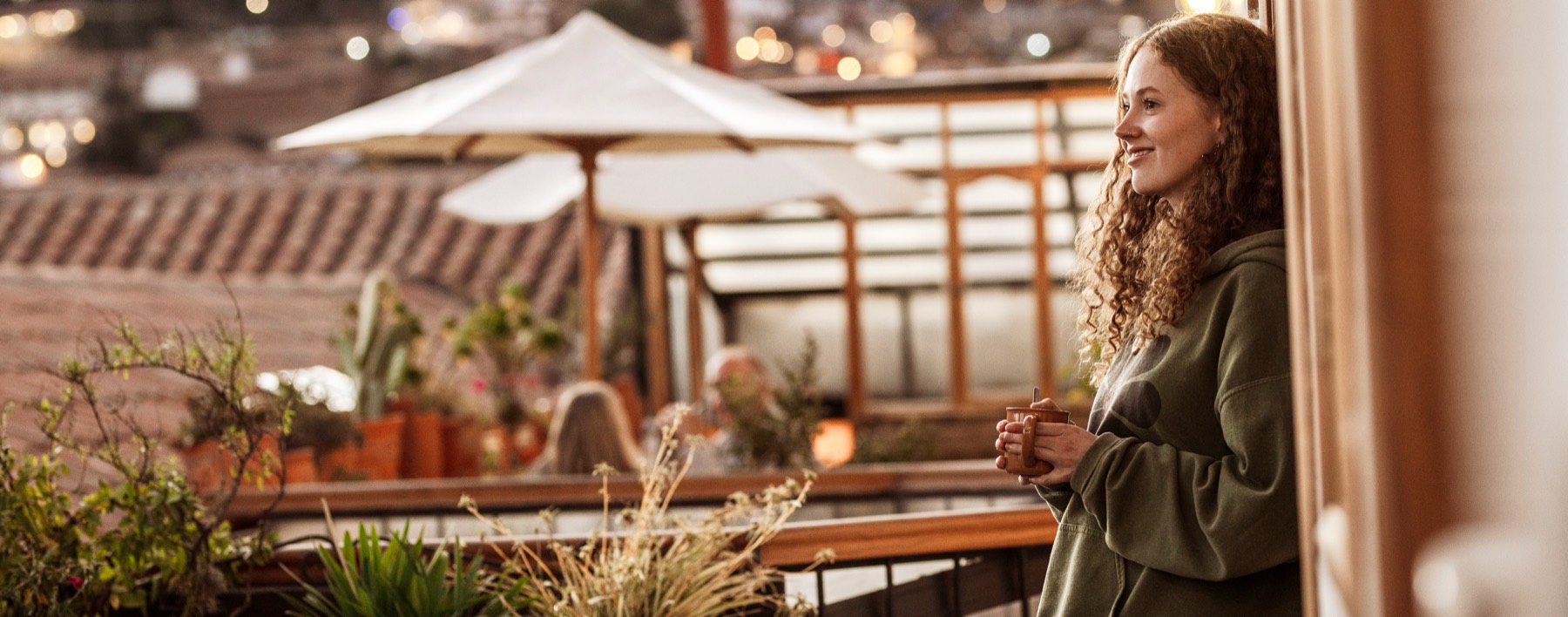 A guest with her cup on the terrace at dusk